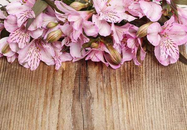 Розовые цветы на деревянном фоне